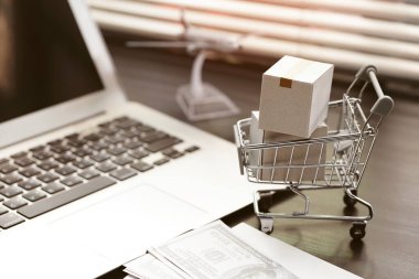 İnternetten alışveriş konsepti. Alışveriş arabasındaki karton kutular ev bilgisayarındaki bilgisayarda.