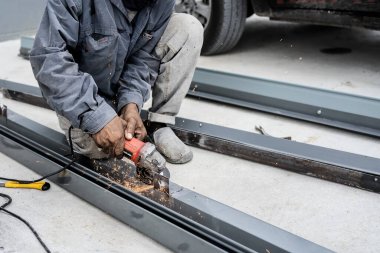Fabrikada metal kesme makinesi kullanan işçiler