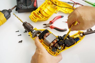 Elektrikli matkabın düğmelerini değiştirmek için tamirci, eski matkap uzun süre kullanıldıktan sonra yıpranmaya başlar                              