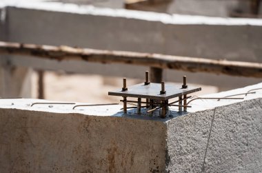 Çelik taban levhası beton, inşaat ve inşaat konseptiyle J-bolt ve çelik çubukla sabitlenmiş.