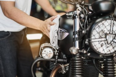 Motosikletli temizlikçi, garajdaki benzin deposuna cilalı ve kaplama cilası. motosiklet bakım ve onarım konsepti.
