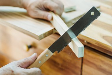 carpenter using Japanese saw or pull saw ,Crosscutting on wood on table, DIY maker and woodworking concept. selective focus clipart