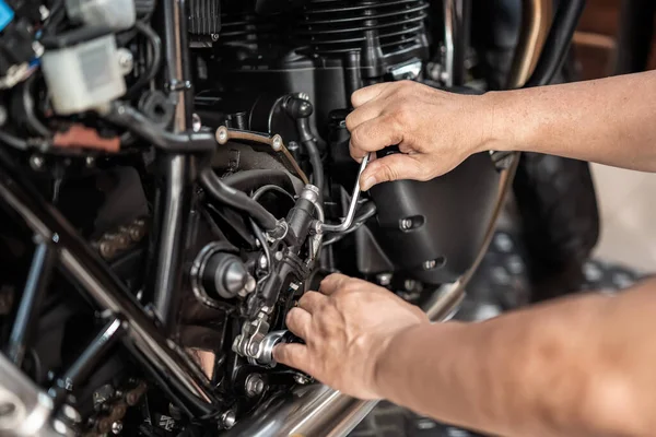 렌치를 사용하는 기계식 오토바이 뒷부분 Hydraulic 브레이크 펌프를 제거하고 차고에서 — 스톡 사진