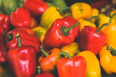 Bir grup kırmızı ve sarı dolmalık biber ve düşük güneş ışığı.