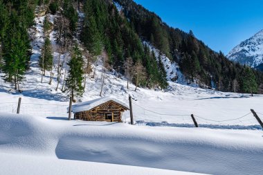 Derin, el değmemiş bir kar tarlasında ahşap kulübe. Kış manzarasında mavi gökyüzü kayak merkezi Grossarlberg Salzburg Avusturya 'da..