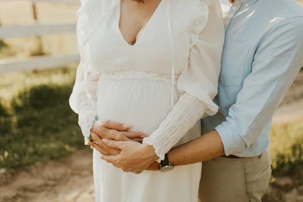 妊娠中のカップル 腹に手をつないでいるカップル 妊娠の概念 夕暮れ時の幸せな妊娠中の家族 — ストック写真