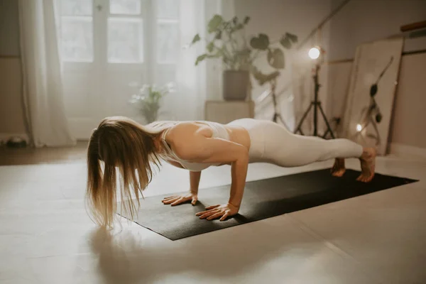 年轻女子练习瑜伽 做俯卧撑运动 做沙图兰加达萨纳姿势 穿运动服 漂亮的瑜伽工作室 — 图库照片