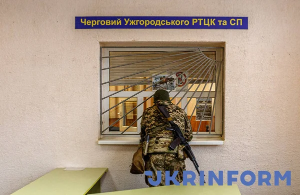 ウズホールド ウクライナ 2022年2月25日 カモフラージュの制服を着た武装した男が ウクライナ西部のザカルパティア地域社会支援センター ウズホルド ザカルパティア地域に描かれています  — 無料ストックフォト