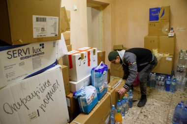 UZHOROD, UKRAINE - 28 FEBRUARY 2022 - Bir adam Ukraynalı savunmacılar, Uzhhorod, Zakarpattia Bölgesi, batı Ukrayna için tıbbi yardım toplayan gönüllü merkezine bir kutu bıraktı. 