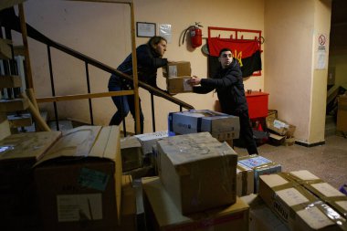 UZHOROD, UKRAINE - FEBRUARY 28, 2022 - Erkekler, Ukrayna 'nın batısındaki Uzhhorod, Zakarpattia Bölgesi, Ukrayna' ya tıbbi yardım sağlayan gönüllü bir merkezden bir kutu geçiriyorlar. 