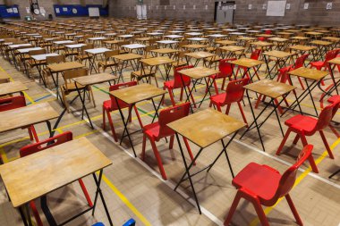 Exam tables and chairs set up in a grid during exam time in a school. clipart
