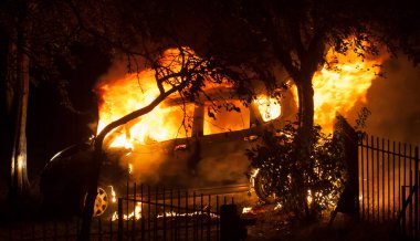 Halka açık bir parkta yanan terk edilmiş bir araba. Araba yanıyor, bir sürü alev ve duman..
