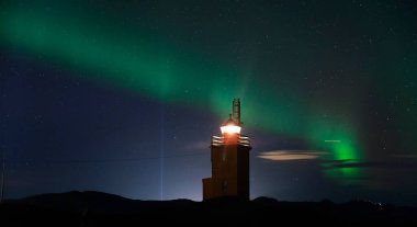 İzlanda 'daki Hopsnes Deniz Feneri' nde inanılmaz Aurora Borealis. İzlanda 'nın güçlü kuzey ışıkları.