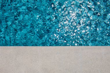 Yüzme havuzunun kenarında güneş yansıması var.