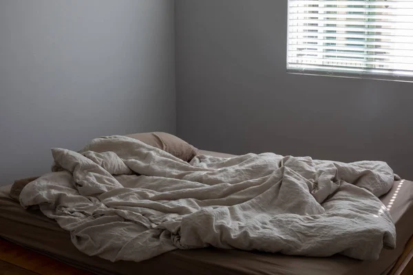 Brudne puste łóżko z pościelą — Zdjęcie stockowe