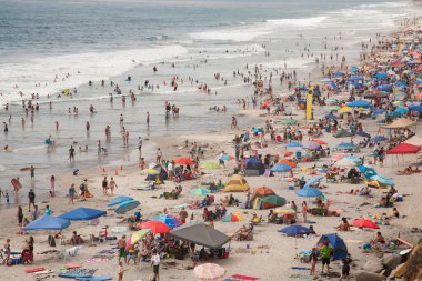 Top view of Moonlight Beach in Encinitas, California, crowded on hot summer day