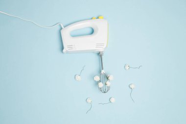 Beyaz elektrikli el çırpma makinesi ve pastel mavi arka planda beyaz gül çiçeklerinden oluşan yaratıcı bir kavram. Yemekleri karıştırmak için ev yapımı mutfak aleti. Asgari bahar pişirme fikri. Düz görünüm bileşimi yatıyordu.