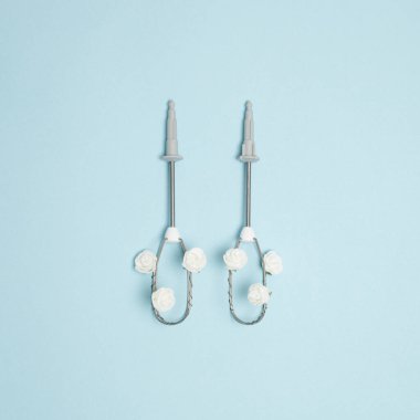 Elektrikli yumurta çırpıcıdan ve pastel mavi arka planda beyaz gül çiçeklerinden oluşan yaratıcı bir kavram. Asgari bahar pişirme fikri. Düz görünüm bileşimi yatıyordu.