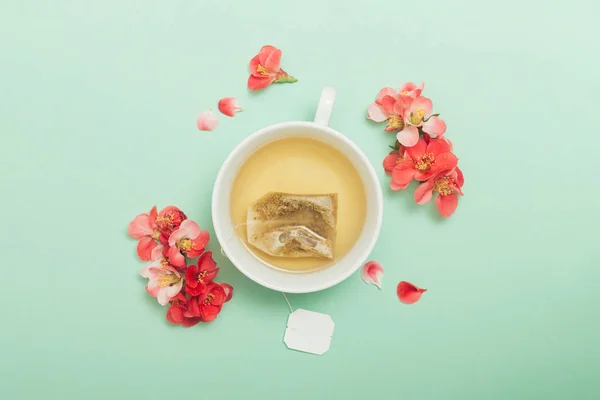 Xícara Cerâmica Branca Com Chá Flores Vermelhas Fundo Verde Pastel — Fotografia de Stock