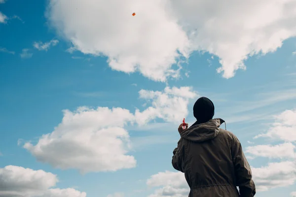 Joven volando una cometa contra el cielo azul — Foto de Stock