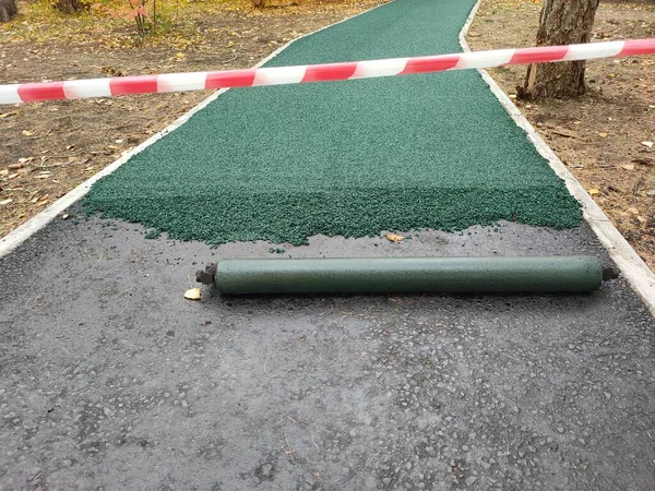 Loopband rubber coating in het park. Zachte coating voor joggen en hardlopen. Naadloze rubber coating van kruimelrubber — Stockfoto