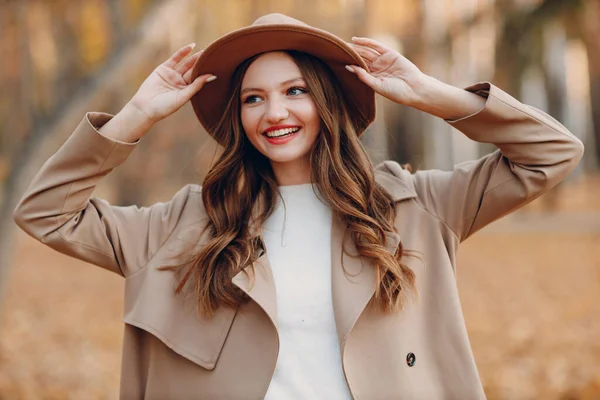 Sonbahar parkında sarı yapraklı genç bir manken. Sonbahar mevsimi modası.