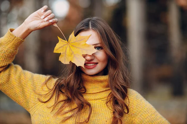 Młoda kobieta modelka w jesiennym parku z żółtymi liśćmi klonu liści. Moda jesienna. — Zdjęcie stockowe