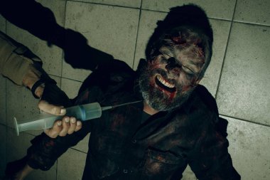 Elinde aşı şırıngası olan zombi ve doktor. Cadılar Bayramı konsepti