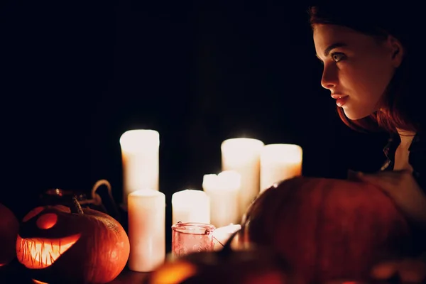 ハロウィンカボチャを作る若い女性ジャックランタン暗いキャンドルと. — ストック写真