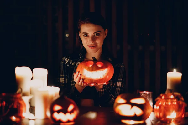 Молодая женщина делает тыквенный фонарь на Хэллоуин. Руки женщины режут тыквы ножом. — стоковое фото