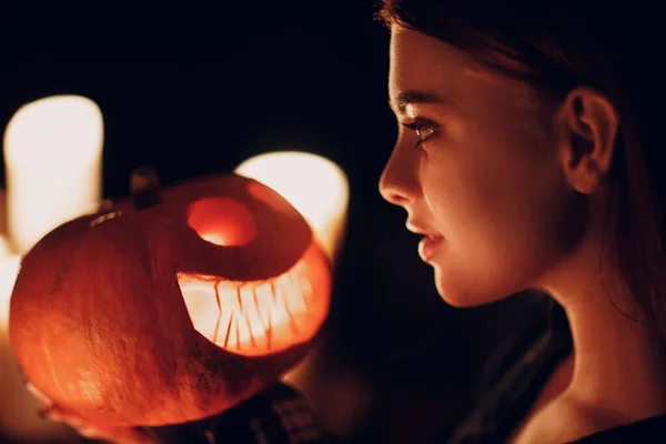 Молодая женщина делает Хэллоуин тыква Джек-о-фонарь со свечами в дар — стоковое фото