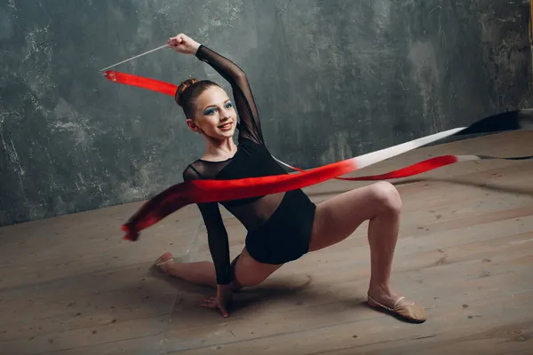 Jong meisje professionele gymnaste vrouw ritmische gymnastiek met lint in studio — Stockfoto