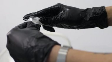 Kozmetik uzmanı dudak mikropateni dövme prosedürü yapmadan önce aletleri kontrol ediyor.