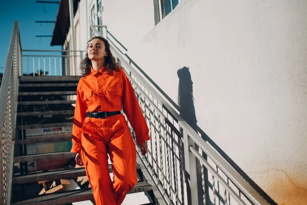 Joven morena rizada mujer en traje naranja. Mujer en mono colorido retrato. — Foto de Stock