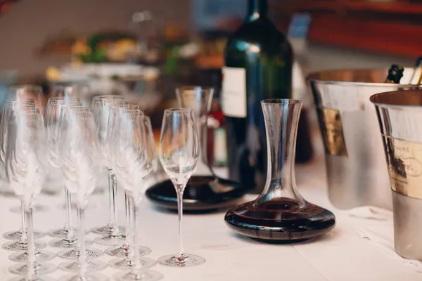 O garçom derrama vinho tinto de elite no decantador na mesa do restaurante — Fotografia de Stock