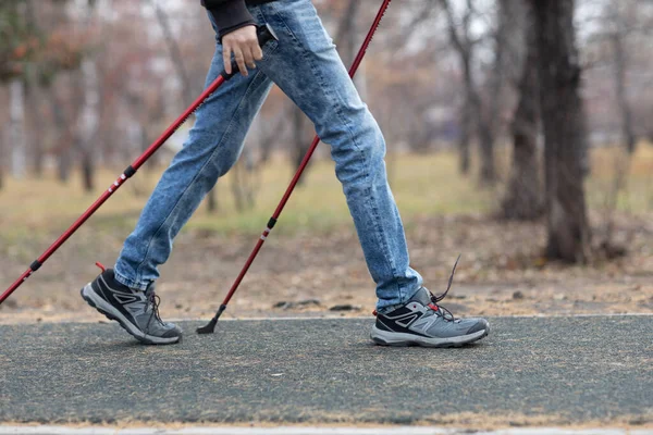 Un joven camina con bastones escandinavos. Estilo de vida saludable. —  Fotos de Stock