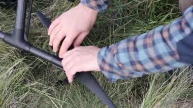 Erkek pilot, havadan uçmadan önce kuadkopter drone 'u kontrol ediyor..