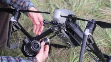 New York, ABD - 18 Eylül 2021: DJI Inspire 2 kuadcopter drone 'u kontrol eden ve havadan uçmadan önce kamera lensi takan ve çekim yapan adam pilot.