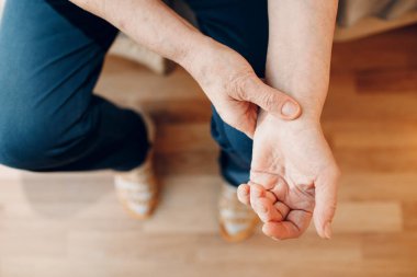 Yaşlı kadın, kendi kol nabzını ölçüyor. Yaşlı kadın kalp sağlığı