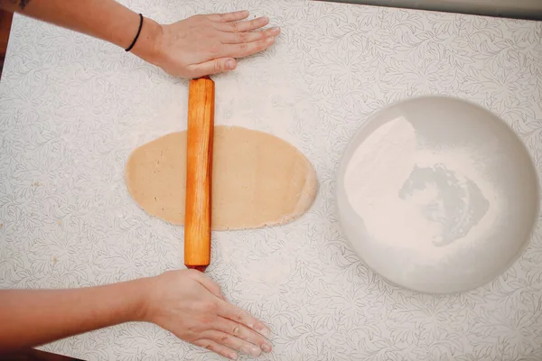 Pastelero lanza masa con rodillo y hace deliciosas galletas de jengibre. Cocinar y decorar el postre —  Fotos de Stock