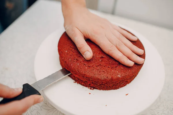 Pastelero hace delicioso pastel de terciopelo rojo. Cocinar pastel base —  Fotos de Stock