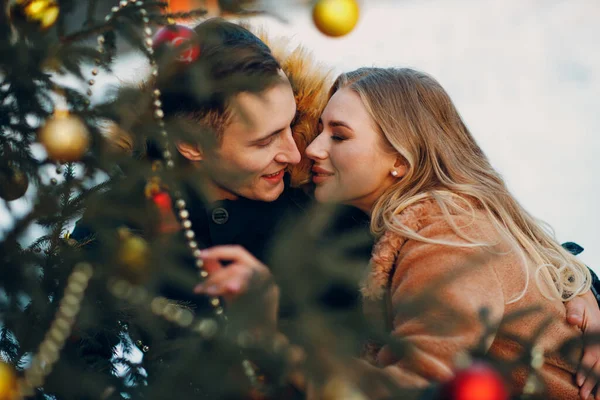Junges erwachsenes Paar schmückt Weihnachtsbaum im Winterwald. Konzept für Neujahrsfeier. — Stockfoto