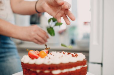 Pasta şefi lezzetli kırmızı kadife pasta yapar. Yemek yapmak ve tatlı süslemek