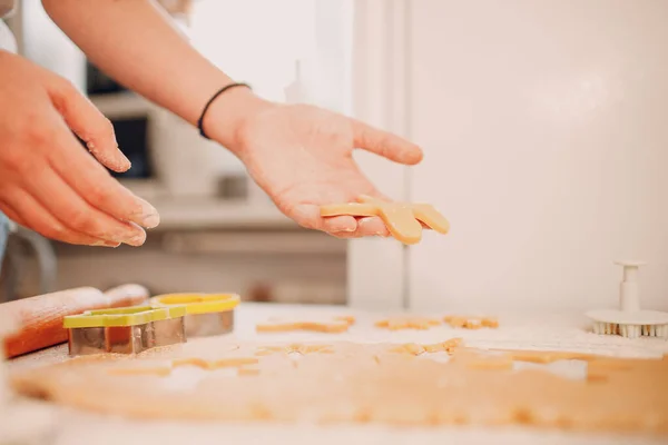 Mãos de mulher formar moldes cortadores de massa de gengibre e faz deliciosos biscoitos de gengibre de Natal. Cozinhar e decorar sobremesa de Natal — Fotografia de Stock