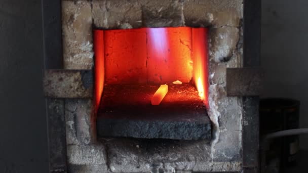 Fierarul forjează cuptorul cu flacără fierbinte. Smith bucată de fier de încălzire din oțel în foc de forjare roșu-fierbinte — Videoclip de stoc