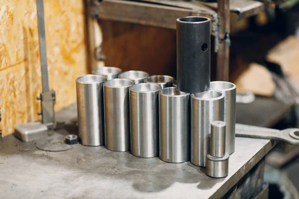 Nuevos tubos de pernos roscados de acero en la mesa en fábrica — Foto de Stock