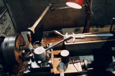 Turner işçisi fabrikadaki torna makinesinde çalışıyor..