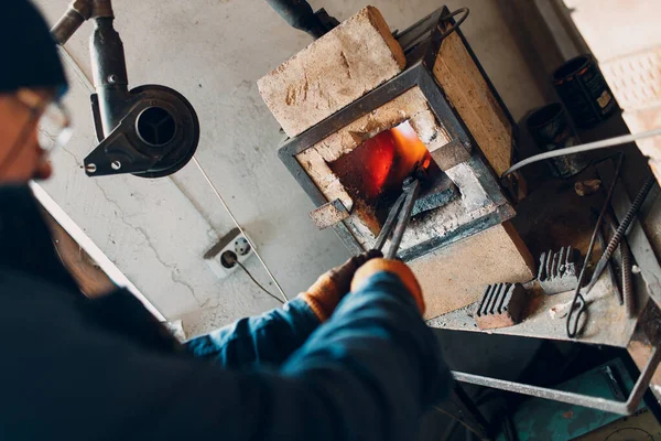 Blacksmith menempa oven dengan api panas. Smith memanaskan besi baja dalam api tempa panas — Stok Foto