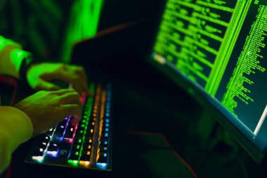 Bilgisayar yazılımı kullanan ve ikili kod dijital arayüzü hackleyen bir bilgisayar korsanı.
