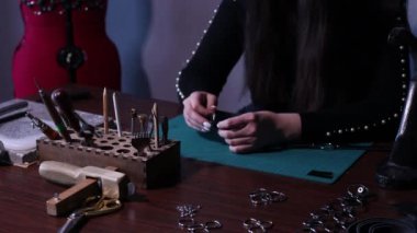 Tanner denen kadın atölyede deri eşyalar yapıyor. Deri işçisinin çalışma süreci